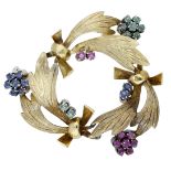 A gem-set brooch, the openwork brooch of stylised foliate sprays with polished ribbon connec...