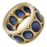 A sapphire dress ring, of openwork design, set with a continuous row of oval sapphire caboch...