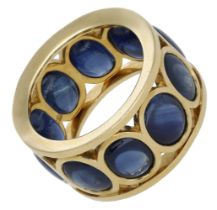 A sapphire dress ring, of openwork design, set with a continuous row of oval sapphire caboch...