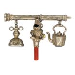 A miniature Victorian whistle/rattle, fob seal and charm, suspended from a propelling pencil...