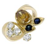 A gem-set dress ring, the stylised foliate spray set with an oval-cut yellow garnet, circula...