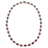 A 19th century garnet riviÃ¨re necklace, composed of oval table-cut garnets, in closed back s...