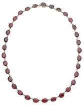 A 19th century garnet riviÃ¨re necklace, composed of oval table-cut garnets, in closed back s...