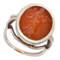 A 19th century hardstone intaglio ring, the carnelian panel carved to depict an annunciatory...