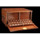 A mahogany coin cabinet, 32 x 26.5 x 17cm, comprising 12 trays single-pierced to house a tot...