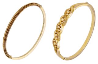 Two late 19th century gold bangles, one with ropetwist detailing, the second of 9ct gold and...