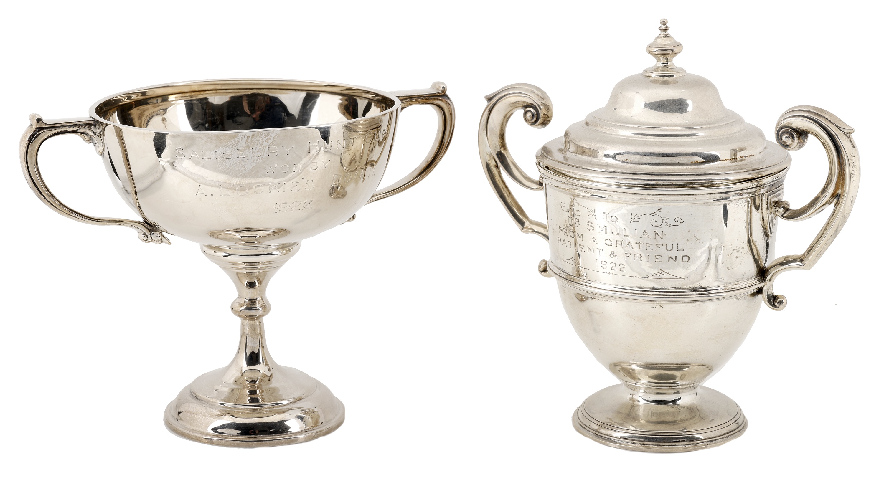 Two silver trophy cups, the first with twin-handled girdled body, with cover and presentatio...