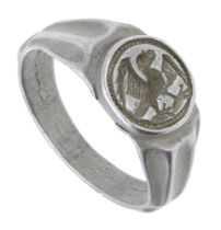 A 15th century silver seal ring, the raised circular bezel set with an eagle rising with win...