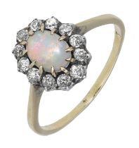 A late 19th century opal and diamond cluster ring, the oval opal cabochon in a surround of o...