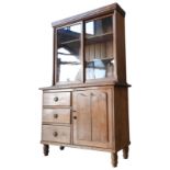 A PINE BOOKCASE ON 19TH CENTURY CONTINENTAL PINE CUPBOARD, the bookcase with two glazed sliding