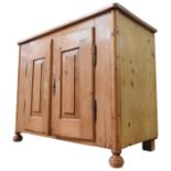 A 19TH CENTURY CONTINENTAL WAXED PINE SIDE CUPBOARD, of simplistic form, with panelled doors