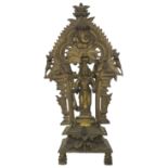 A 19TH CENTURY SOUTH INDIAN BRASS SHRINE, depicting Krishna standing in front of a flaming mandala