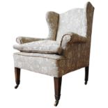 A 19TH CENTURY WING BACK ARMCHAIR, recovered in bold floral damask material, raised on tapered