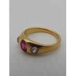 A YELLOW METAL LADIES RING, early 20th century with a central pink stone flanked by two diamonds.