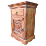 A HARDWOOD BEDSIDE CUPBOARD, 20th century, single frieze drawer above a panelled door, the carved