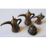 THREE GRADUATED BRASS COFFEE POTS, Omani, 20th century, along with a pierced incense burner, the