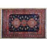A PERSIAN RUG, stylised bird and animal motifs on a red & blue ground 121 x 91 cm
