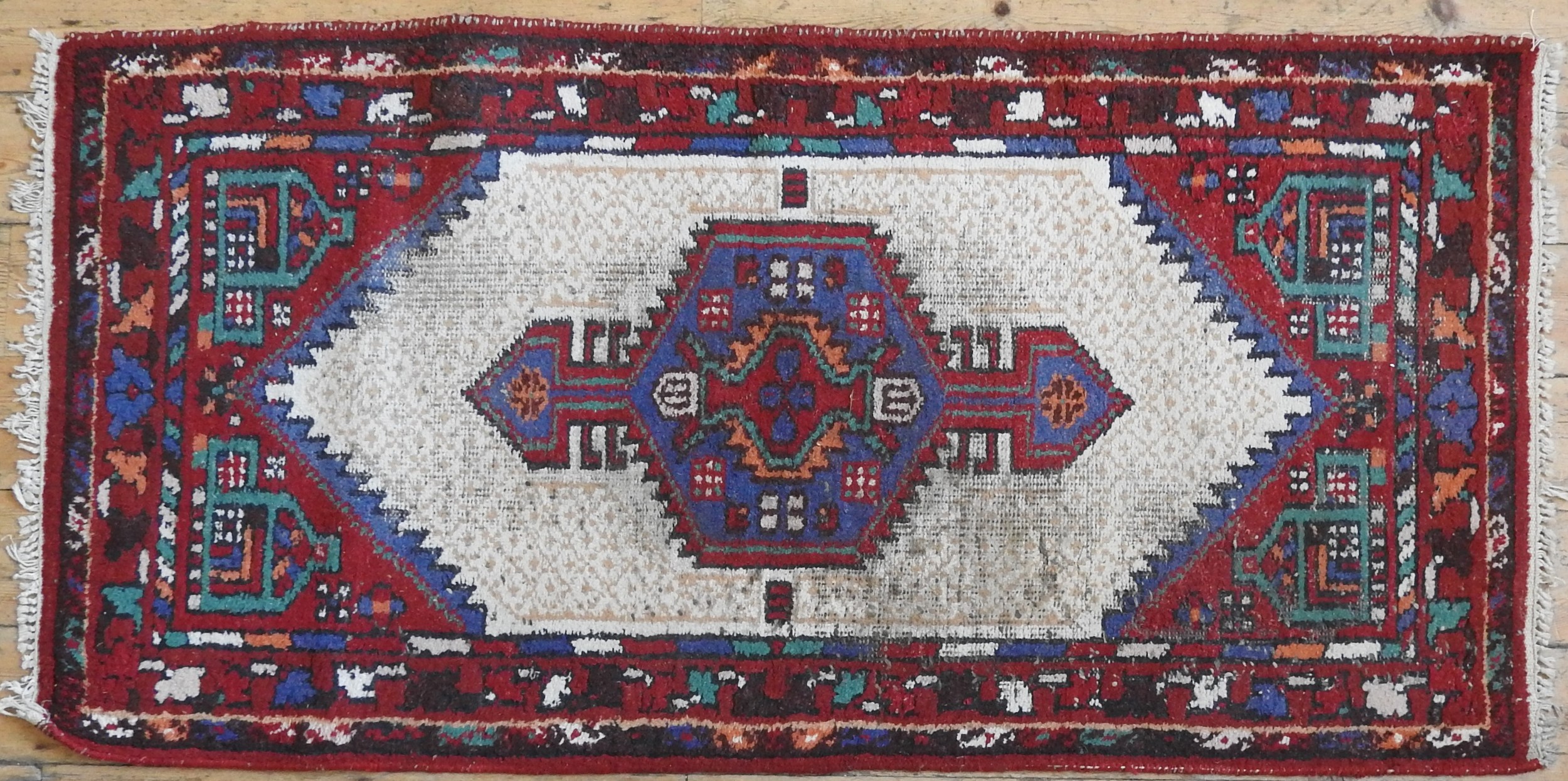 A PERSIAN RUG, with geometric decoration on a cream ground 192 x 97 cm