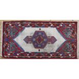A PERSIAN RUG, with geometric decoration on a cream ground 192 x 97 cm