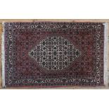 A SMALL PERSIAN RUG, stylised decoration on a rust colour ground 106 x 70 cm