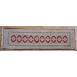 A PERSIAN HAND KNOTTED RUNNER, cream and red ground with a single row of ten gulls 274 x 82 cm