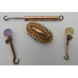 A VICTORIAN ETRUSCAN REVIVAL MOURNING BROOCH, stamped 9ct gold, along with three button hooks, one