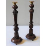 A PAIR OF TURNED WOODEN BALUSTER CANDLESTICKS, reeded pillars on circular cushion plinths, raised on