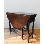 A OAK GATE-LEG DINING TABLE, compact proportions, oval folding top raised on baluster turned legs,