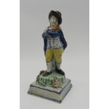 A PRATT WARE FIGURE OF ROBED GENTLEMAN, early 19th century, stood on a naturalistic base raised on a