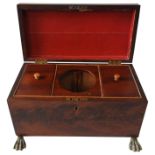 A REGENCY MAHOGANY TEA CADDY, on gilt metal claw feet with lion decorated brass ring handles to