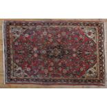 A PERSIAN HAND KNOTTED RUG, floral design on a pale red ground 167 x 103 cm