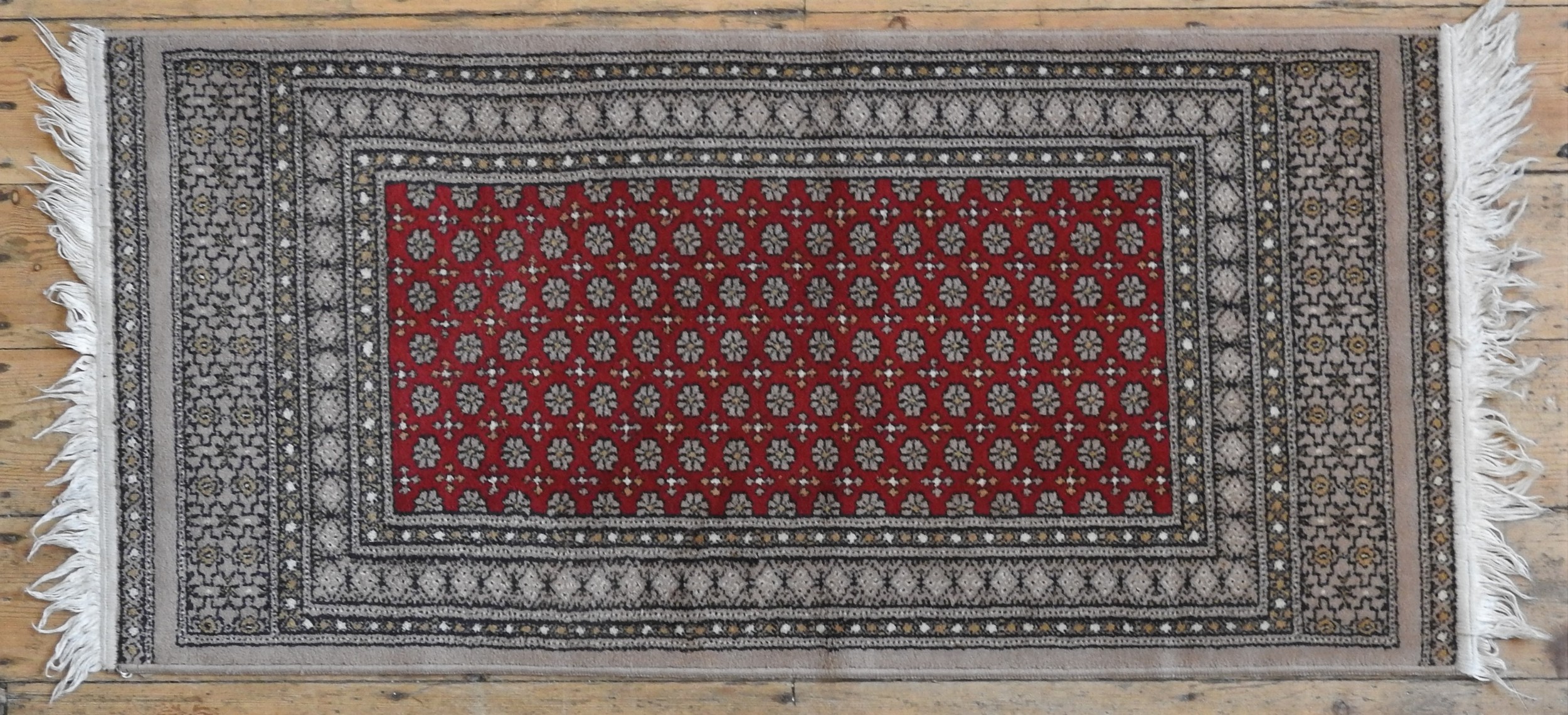 A CONTEMPORARY PERSIAN RUG, stylised decoration on a central red ground 143 x 70 cm