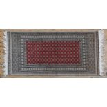 A CONTEMPORARY PERSIAN RUG, stylised decoration on a central red ground 143 x 70 cm