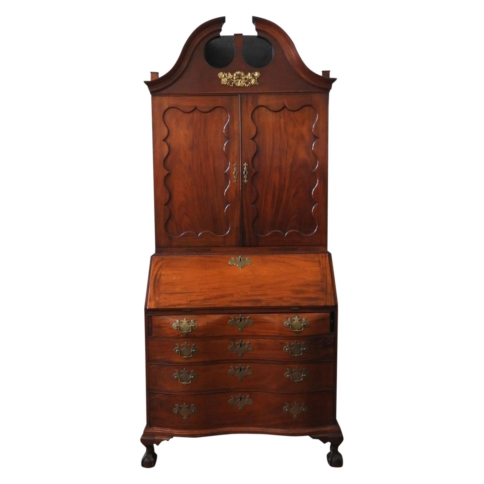 AN AMERICAN MAHOGANY BUREAU BOOKCASE, two panelled doors sat atop a bombe-style bureau base with