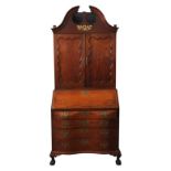 AN AMERICAN MAHOGANY BUREAU BOOKCASE, two panelled doors sat atop a bombe-style bureau base with