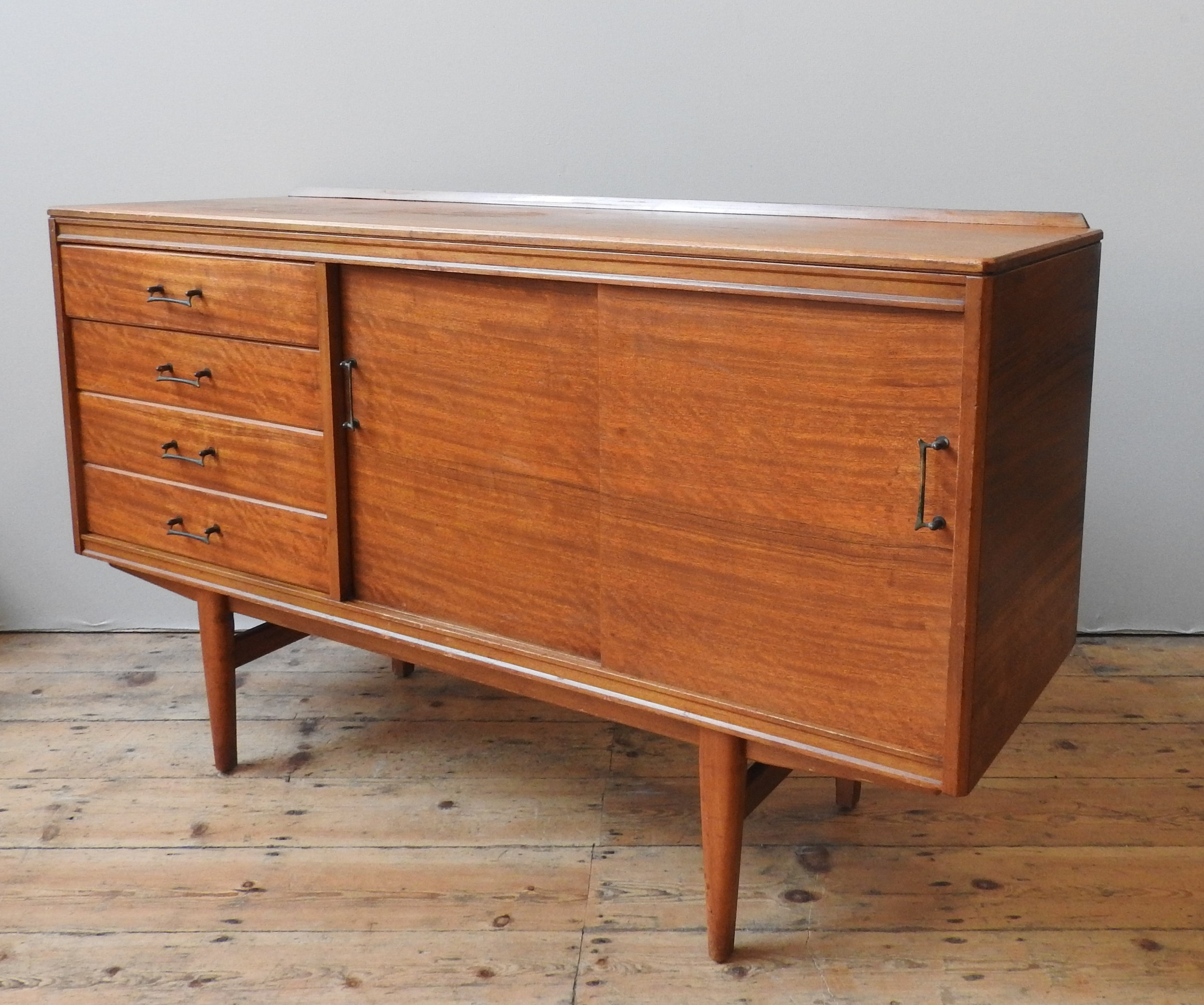 A TEAK MID CENTURY SIDEBOARD, circa 1960, four short drawers beside two sliding doors, enclosing two