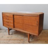 A TEAK MID CENTURY SIDEBOARD, circa 1960, four short drawers beside two sliding doors, enclosing two