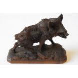 A CARVED WOODEN FIGURE OF A WILD BOAR, in the Black Forest style, raised on a naturalistic plinth