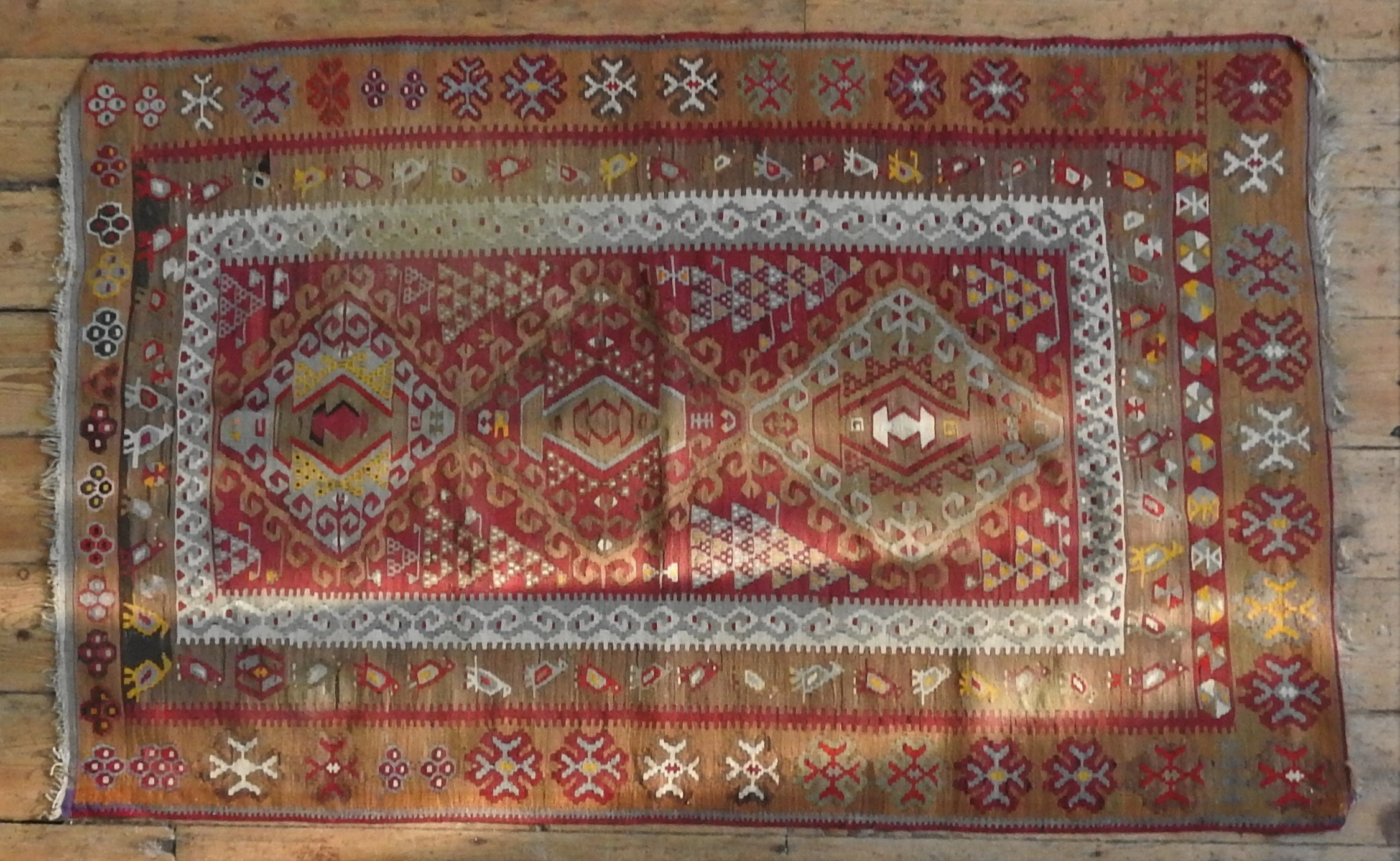 A KHELIM RUG, geometric patterns on a beige and red ground 173 x 106 cm