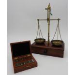 A SET OF VINTAGE ANALYTICAL WEIGHTS AND BRASS APOTHECARY SCALES, the weights in their original box