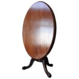 A 19TH CENTURY MAHOGANY LOO TABLE, tilting oval top on a turned baluster base on three down swept