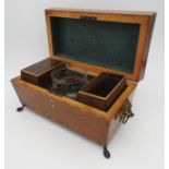 A REGENCY MAHOGANY TEA CADDY, of sarcophagus form, raised on brass feet with feline mask side