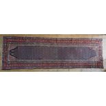 A HAND KNOTTED BELOUCH HALL RUNNER, deep border, repeating motifs on a dark blue ground 440cm X