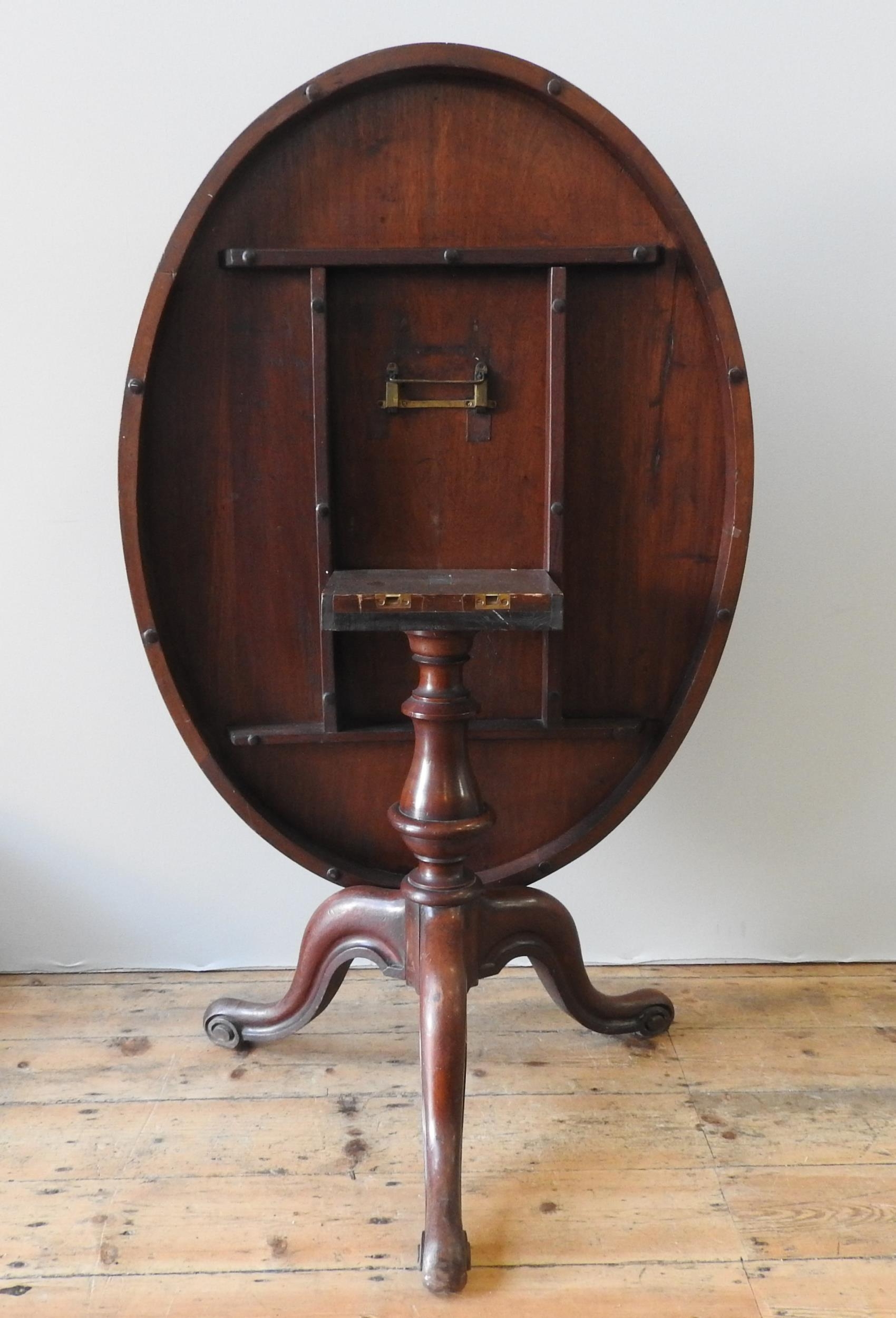 A 19TH CENTURY MAHOGANY LOO TABLE, tilting oval top on a turned baluster base on three down swept - Image 2 of 4