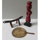 A TRIBAL HEAD REST, RED PAINTED TRIBAL FIGURE AND AN ANIMAL HIDE FAN, the tribal figure mounted on a