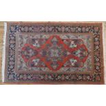 A GOOD PERSIAN BORDER PATTERN CARPET, with floral decoration on a rust coloured ground 219 x 137 cm