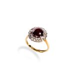 GARNET AND ROSE CUT DIAMOND RING set with a large claw set garnet cabochon surrounded by a halo of