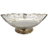 A LATE VICTORIAN SILVER BASKET, elliptical form with reticulated sides, raised on a socle foot,