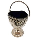 A SILVER SUGAR BASKET, with blue glass liner, beaded swing handle, hand cut body with repousse