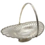 A LARGE SILVER FRUIT BASKET, oval form with flared fluted design, bead work edging and a swing